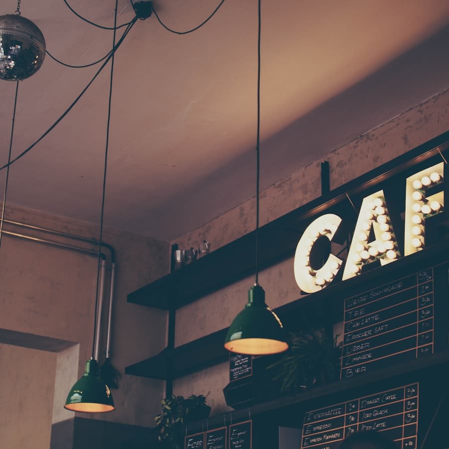 Green enamel lamps lit above the café's back shelves