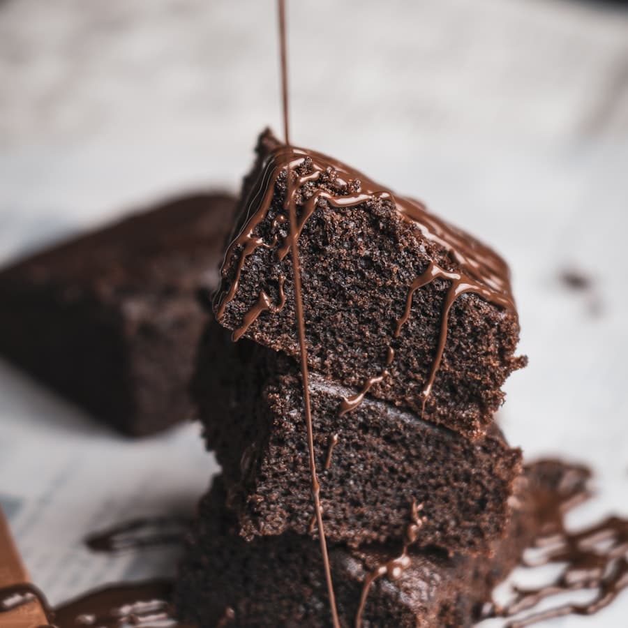 Chocolate sauce drizzled over a stack of brownies